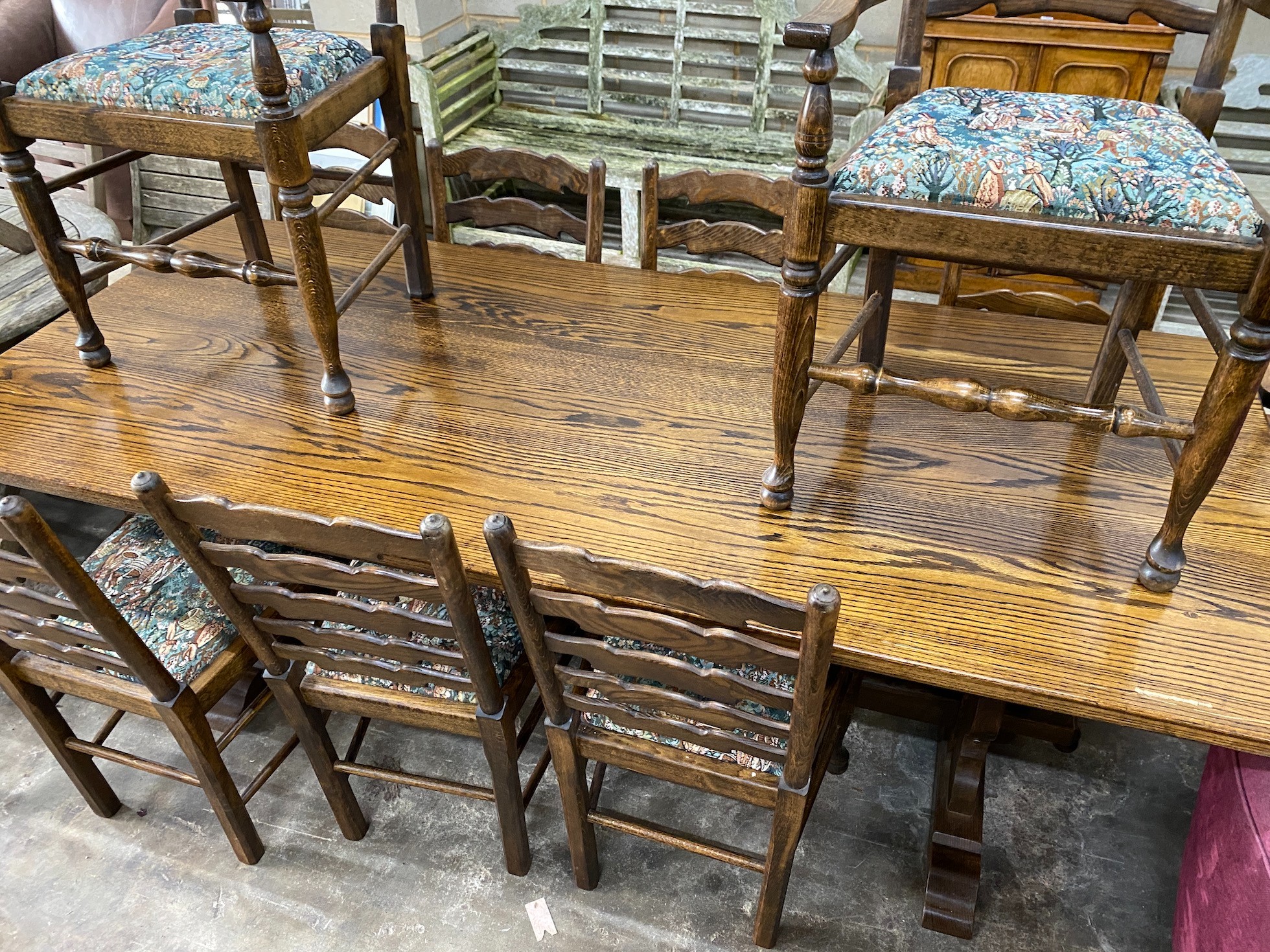 An 18th century style rectangular oak refectory dining table, length 210cm, depth 92cm, height 76cm together with a set of ten oak and beech ladder back dining chairs (two with arms) *Please note the sale commences at 9a